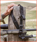 Wojcik demonstrates another way to use a rifle sling to enhance your shooting position. Here he uses it to let the rifle hang from the fence post \.