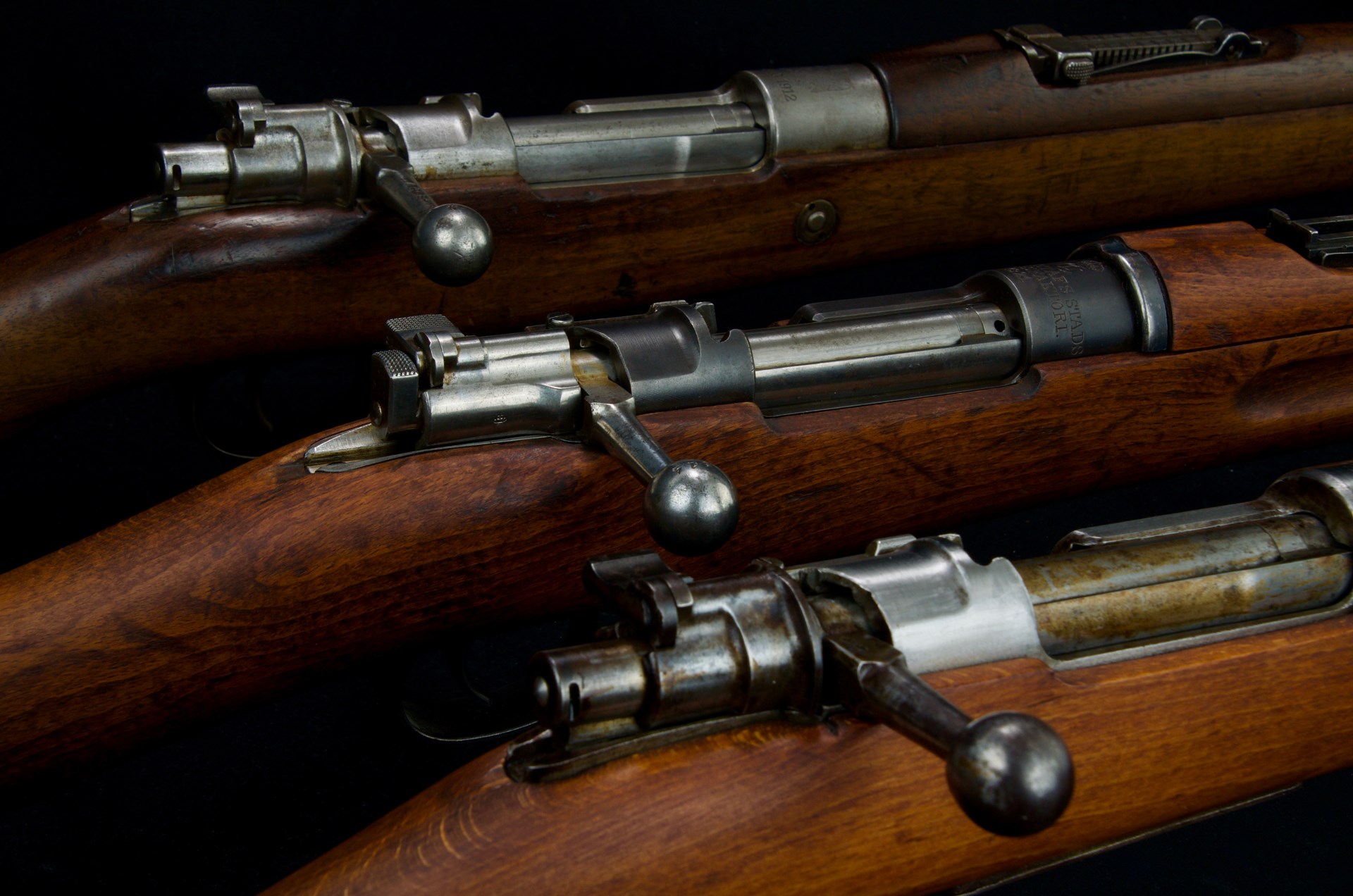 three mauser bolt-action rifles closeup receiver action bolt assembly rifles parts guns metal wood