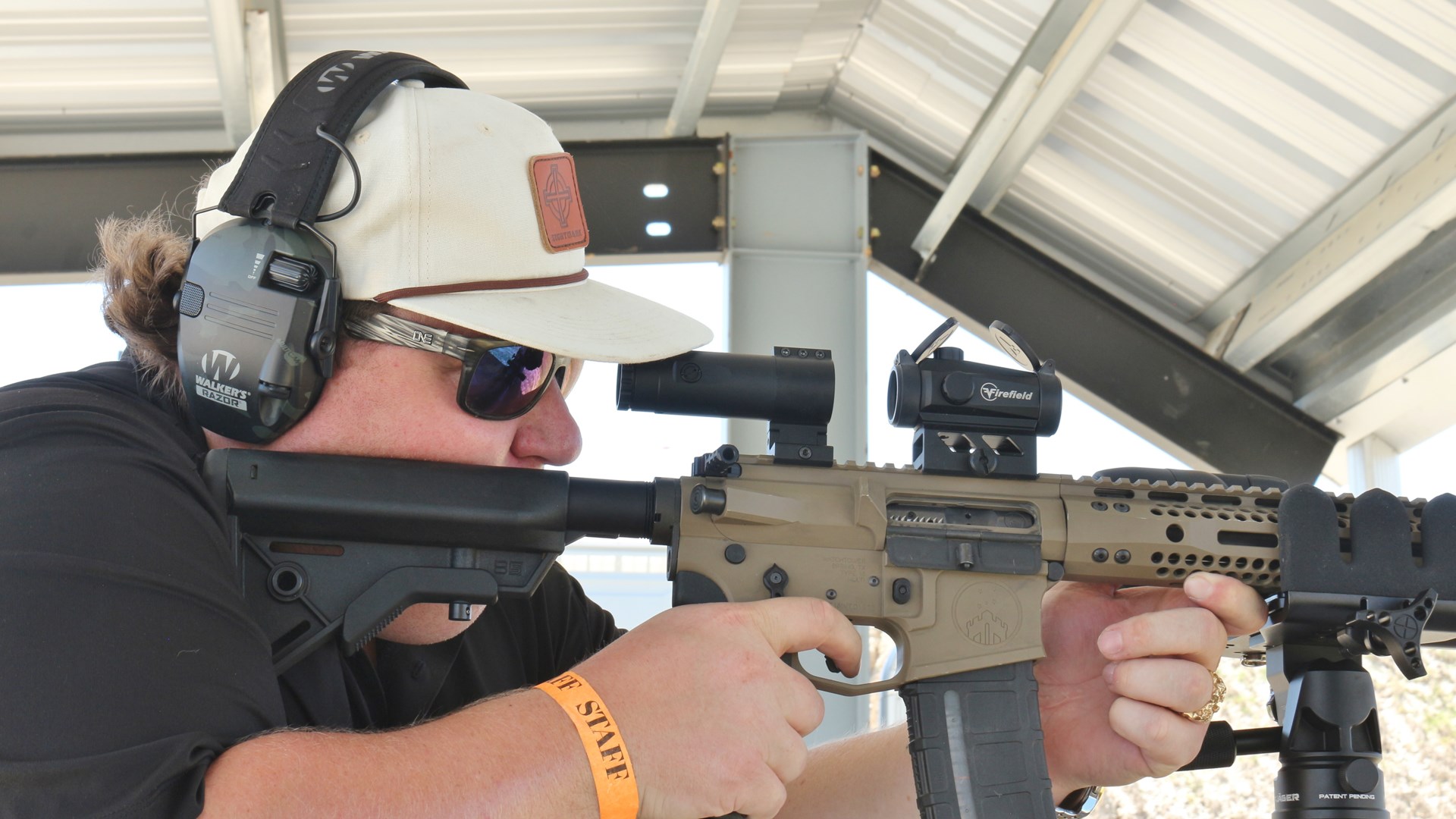 Man shooting rifle with firefield optic at sellmark ranch grand opening under covered roof