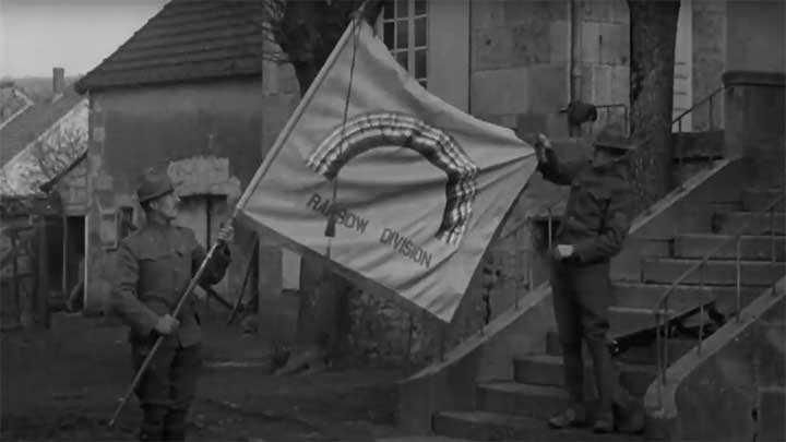 Men of the 42nd Rainbow Division displaying their division flag.