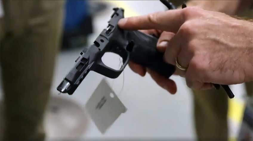 A Smith &amp; Wesson plant employee points out the contours of a newly molded M&amp;P pistol frame.