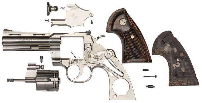 A fully disassembled Colt Python on white.