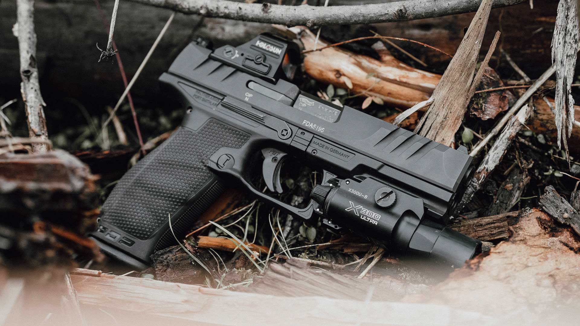 right side pistol handgun black outdoors sticks leaves wet