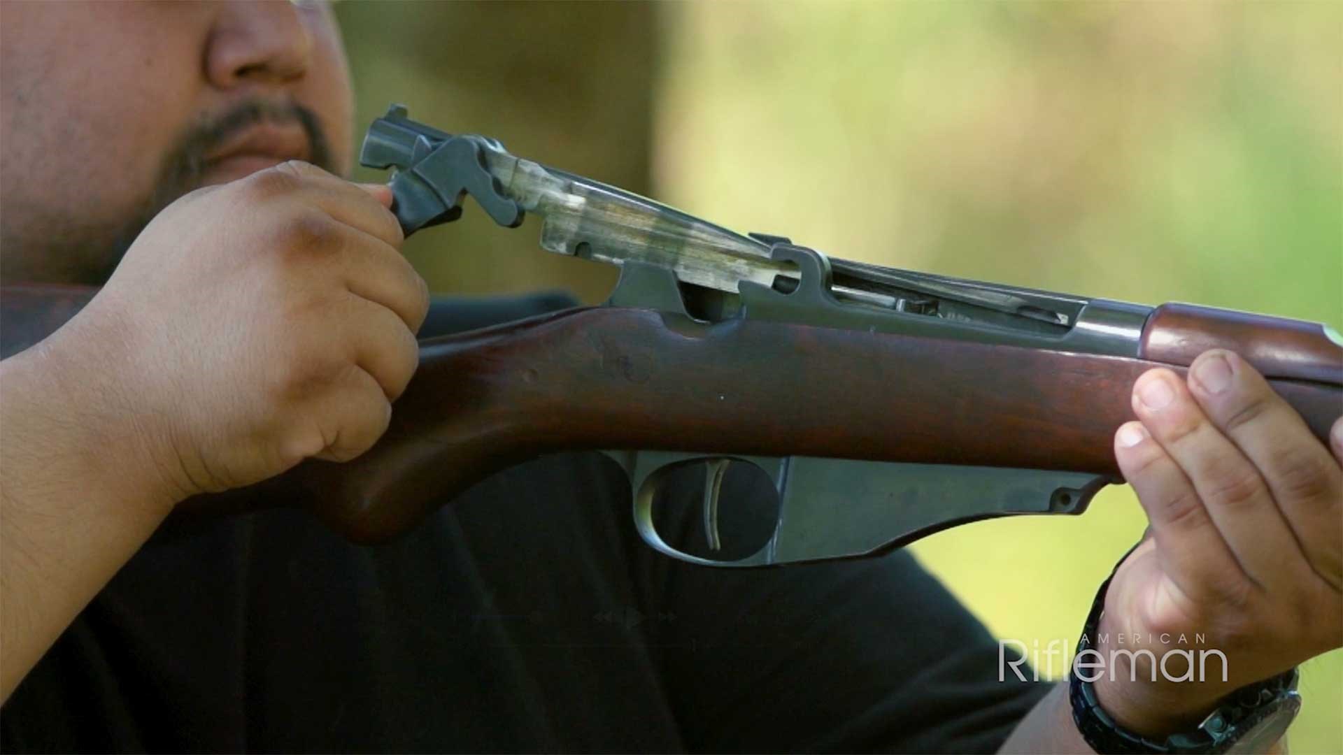 Man operating the bolt of a Model 1895 Lee Navy rifle.