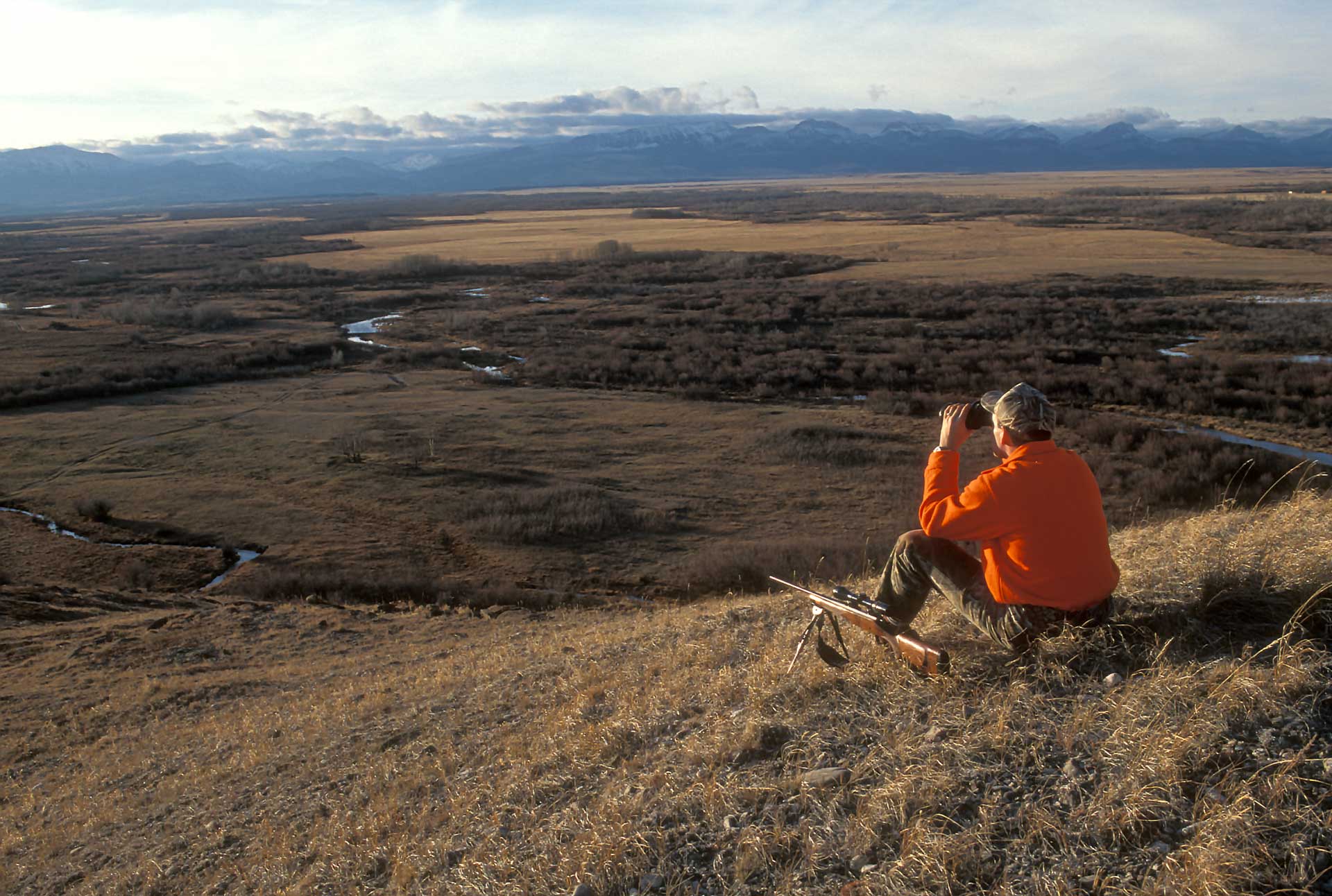 outdoors man hunting orange overlook mountains valley stream hunter