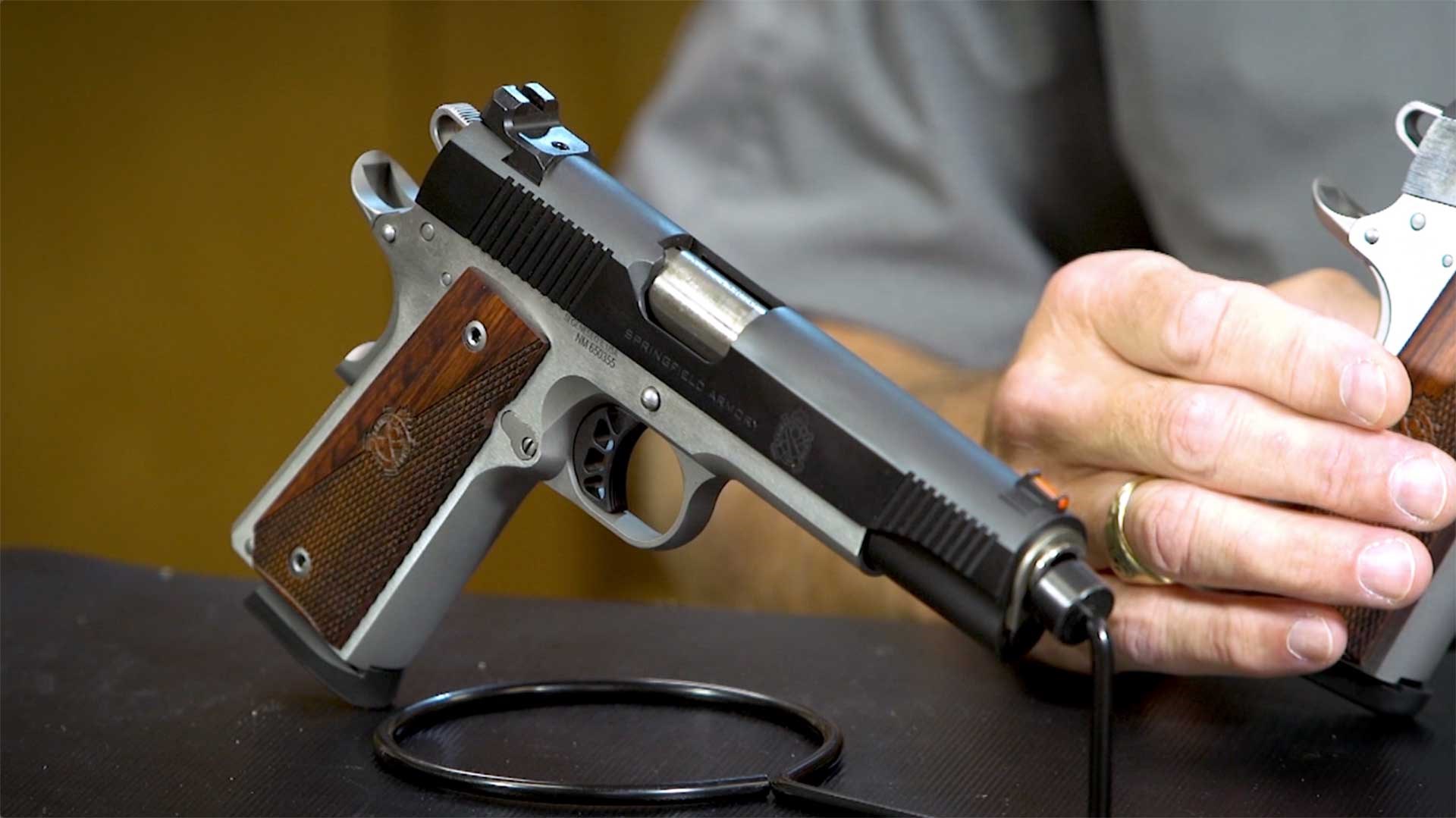 Full-size Springfield Armory Ronin 1911 shown on a table with a hand in the background.