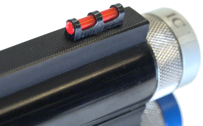 Close-up view of TriStar Arms barrel at the muzzle showing extended silver-colored choke tubes and red fiber-optic sight bead shown on white background.