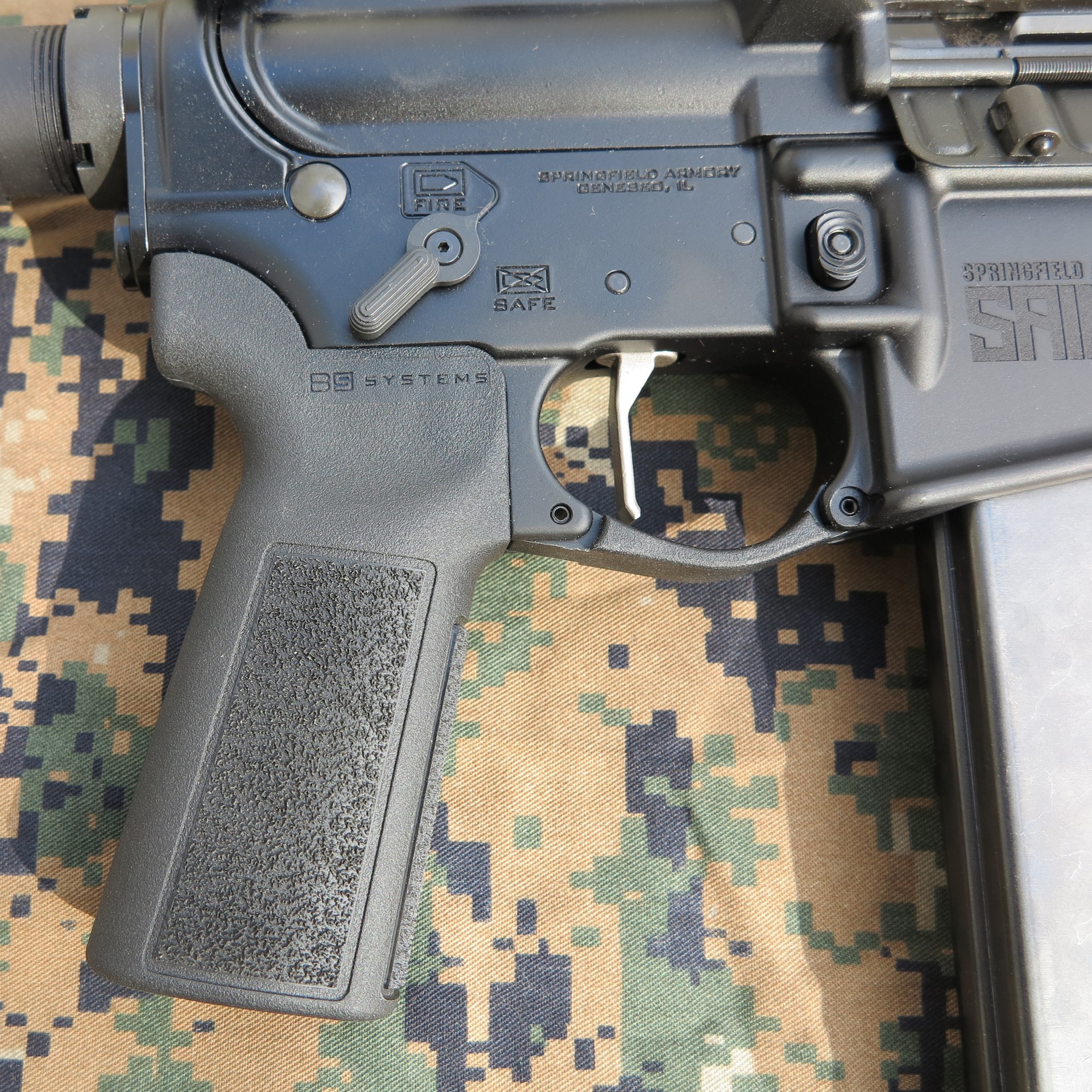 Springfield Armory Saint Victor PCC closeup receiver grip magazine trigger camouflage background fabric
