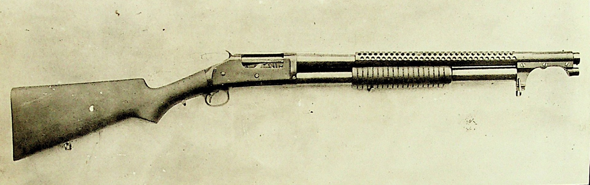 This side profile of a M1897 Winchester riot gun with bayonet adapter shows the typical WWI features: High comb stock, 29 hole-per-row heat shield, and clamp-on bayonet adapter. Document courtesy of Archival Research Group.