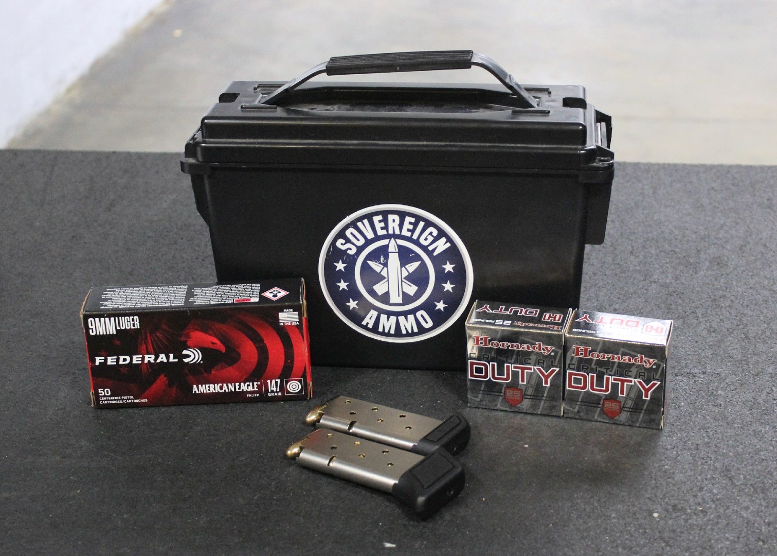 Three boxes of ammunition next to two loaded handgun magazines.