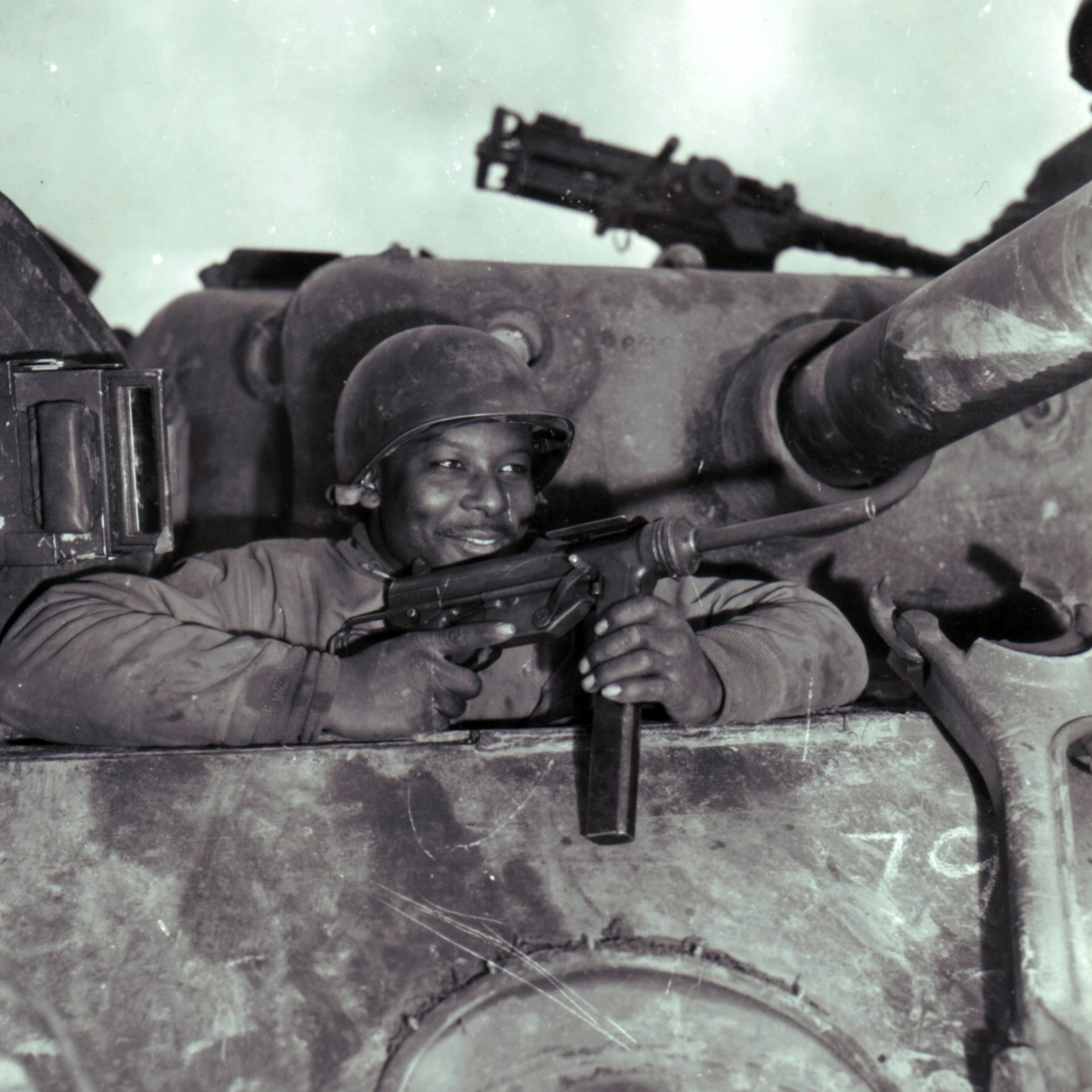 An assistant driver of an M4 Sherman medium tank of the 761st Tank Battalion (the “Black Panthers”) poses with a M3 “Grease Gun” SMG. Outside Nancy, France during the fall of 1944. The collapsing stock M3 SMG (29.1 inches with the stock extended, 21.9 inches with stock retracted) was designed with paratroops and vehicle troops in mind.