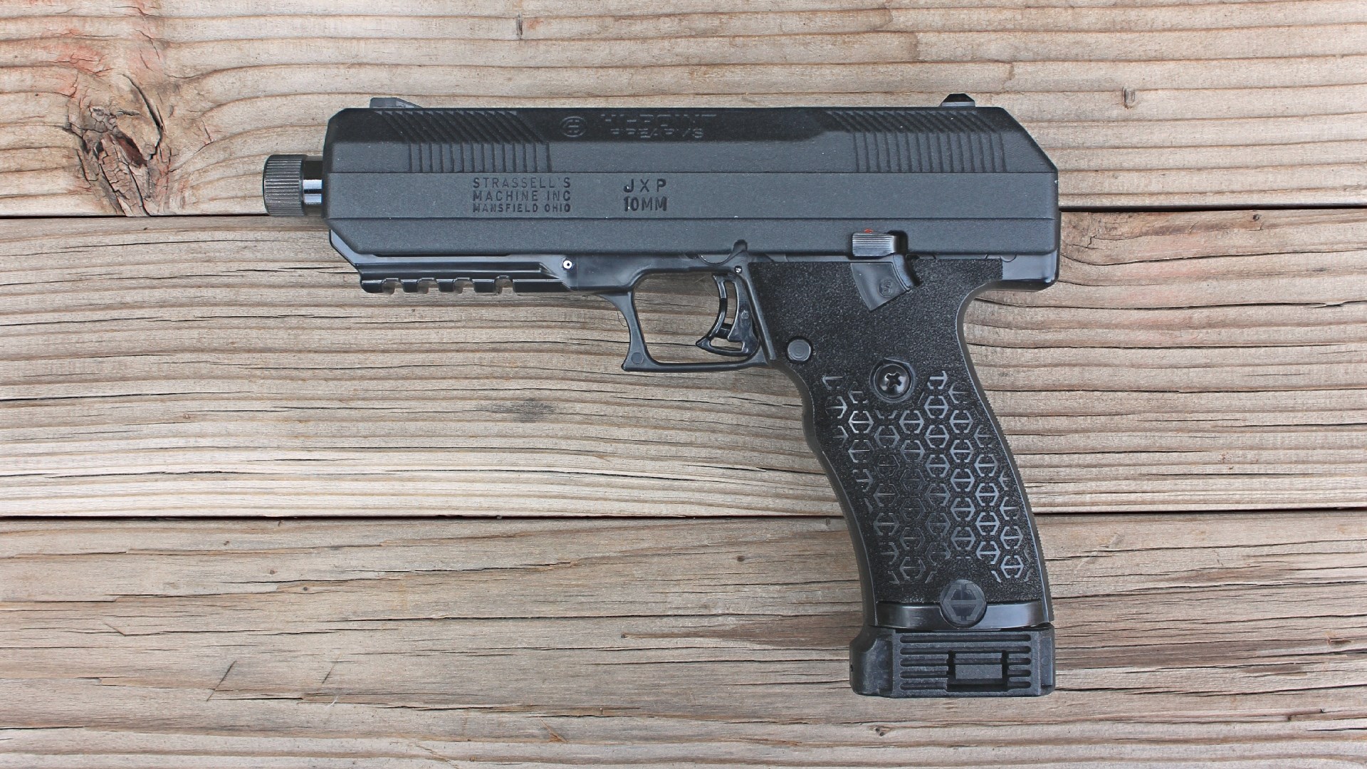 Left-side view of Hi-Point JXP-10 handgun pistol black plastic metal shown on wood boards
