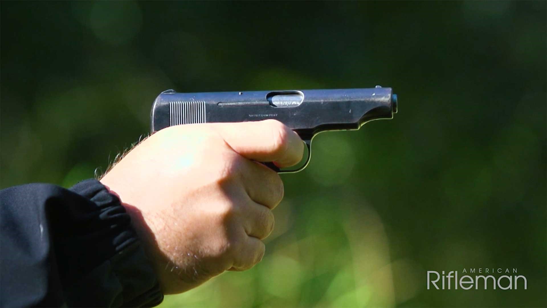 Man aiming the Ortgies pistol on an outdoor range.