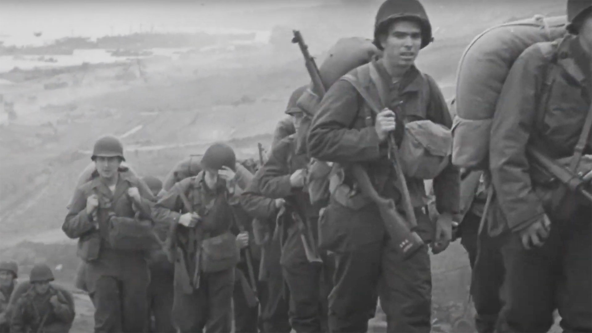 U.S. infantrymen making their way up one of the draws of "Omaha" beach to the interior of Normandy after the landings.