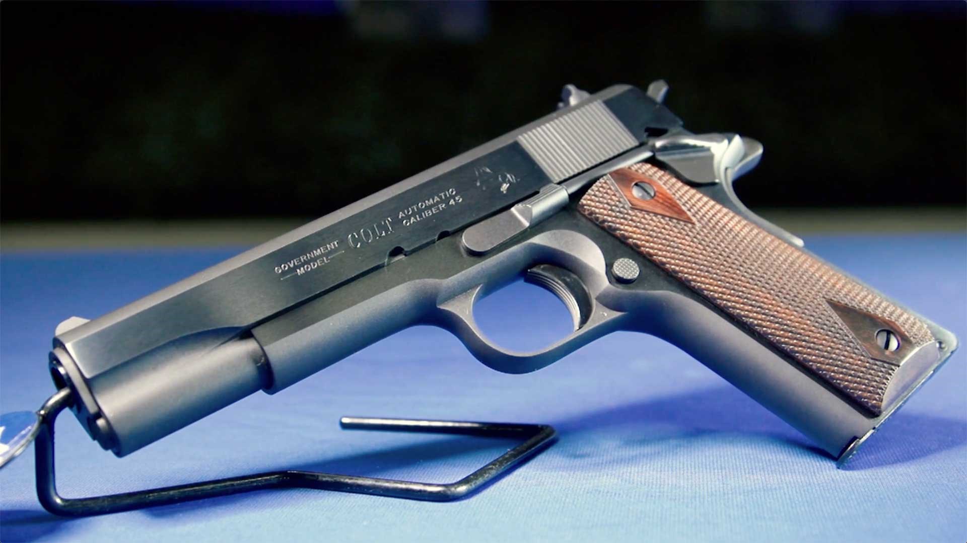 Left side of a Colt 1911 Classic shown on a blue tabletop.