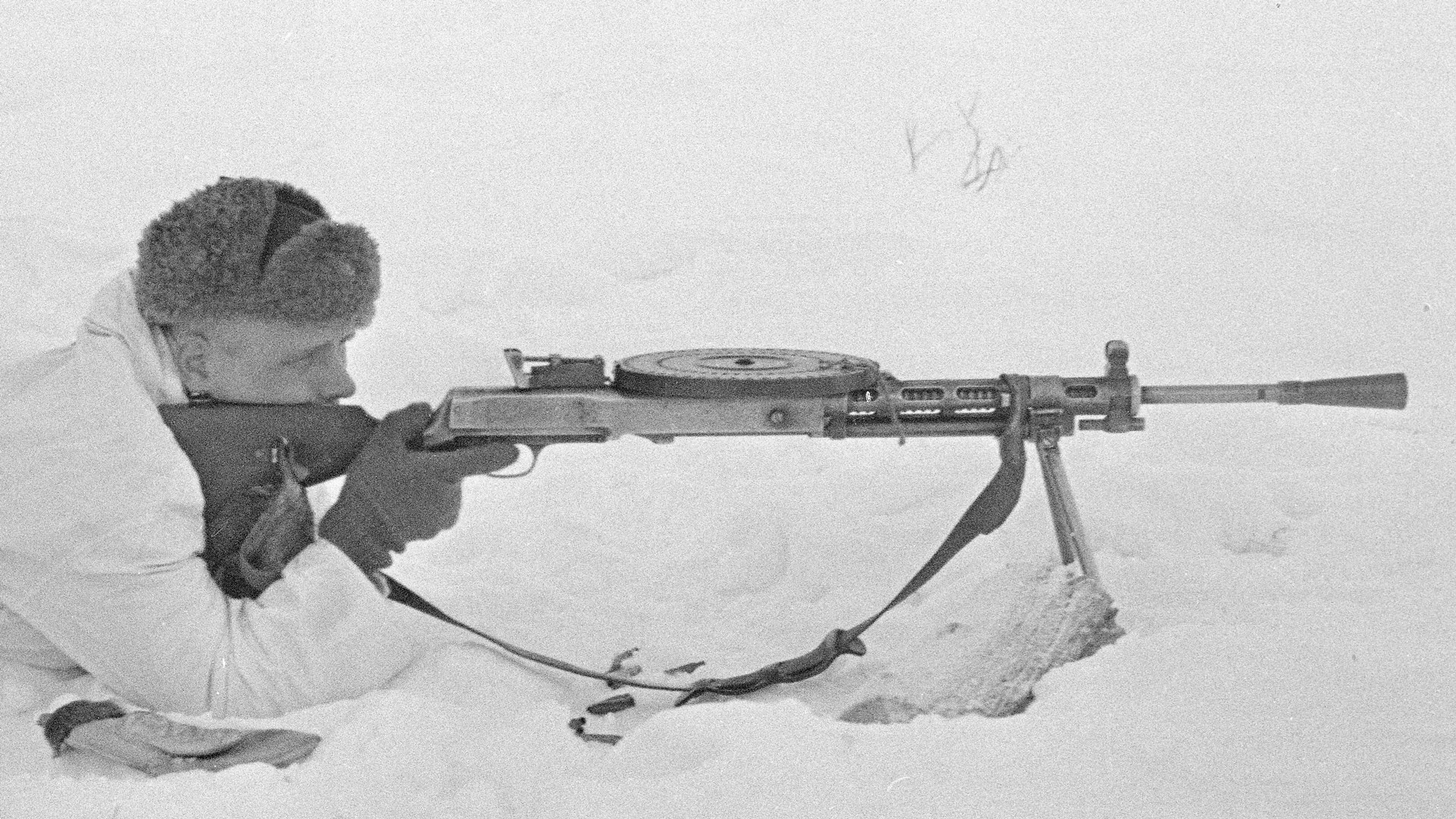Finnish soldier prone position in the snow behind russian DP-28 light machine gun