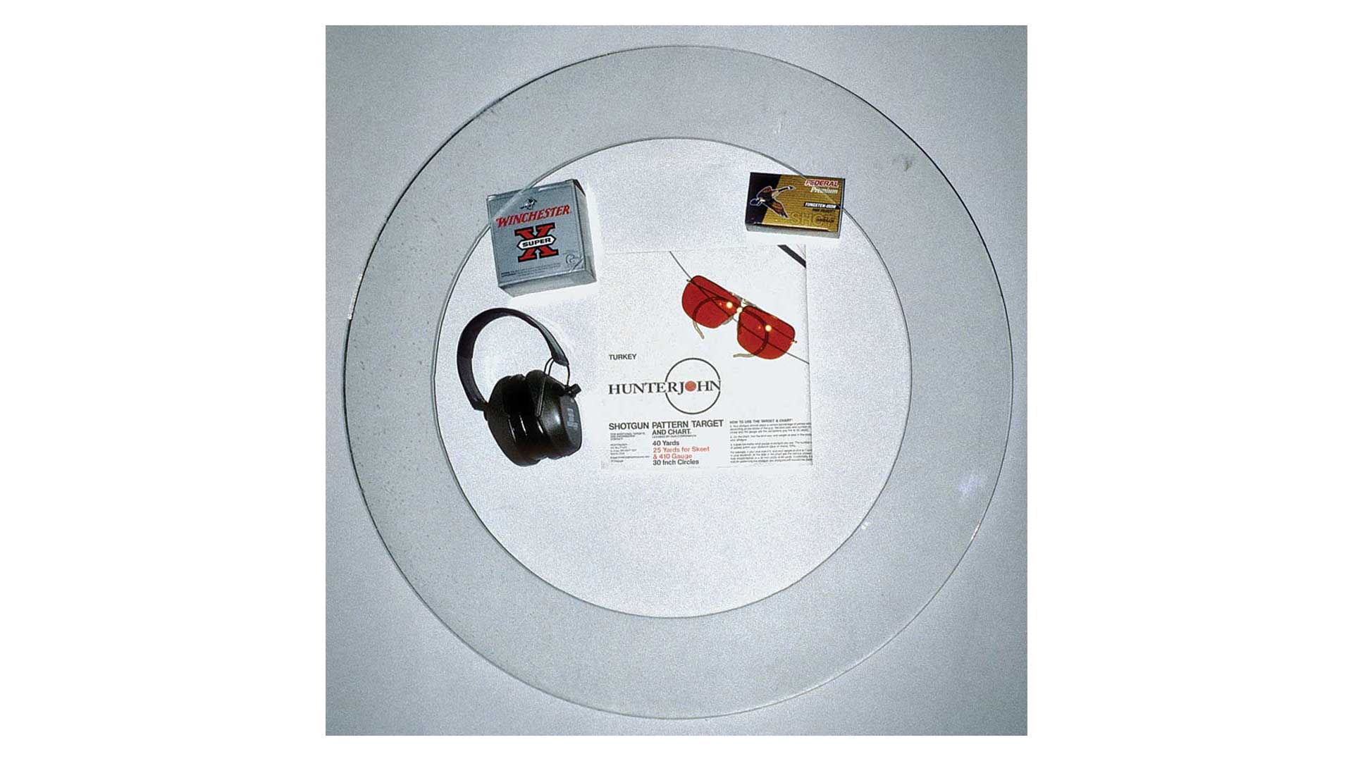 round plexiglass circle earmuffs ammunition glasses target on table for shotgun patterning test