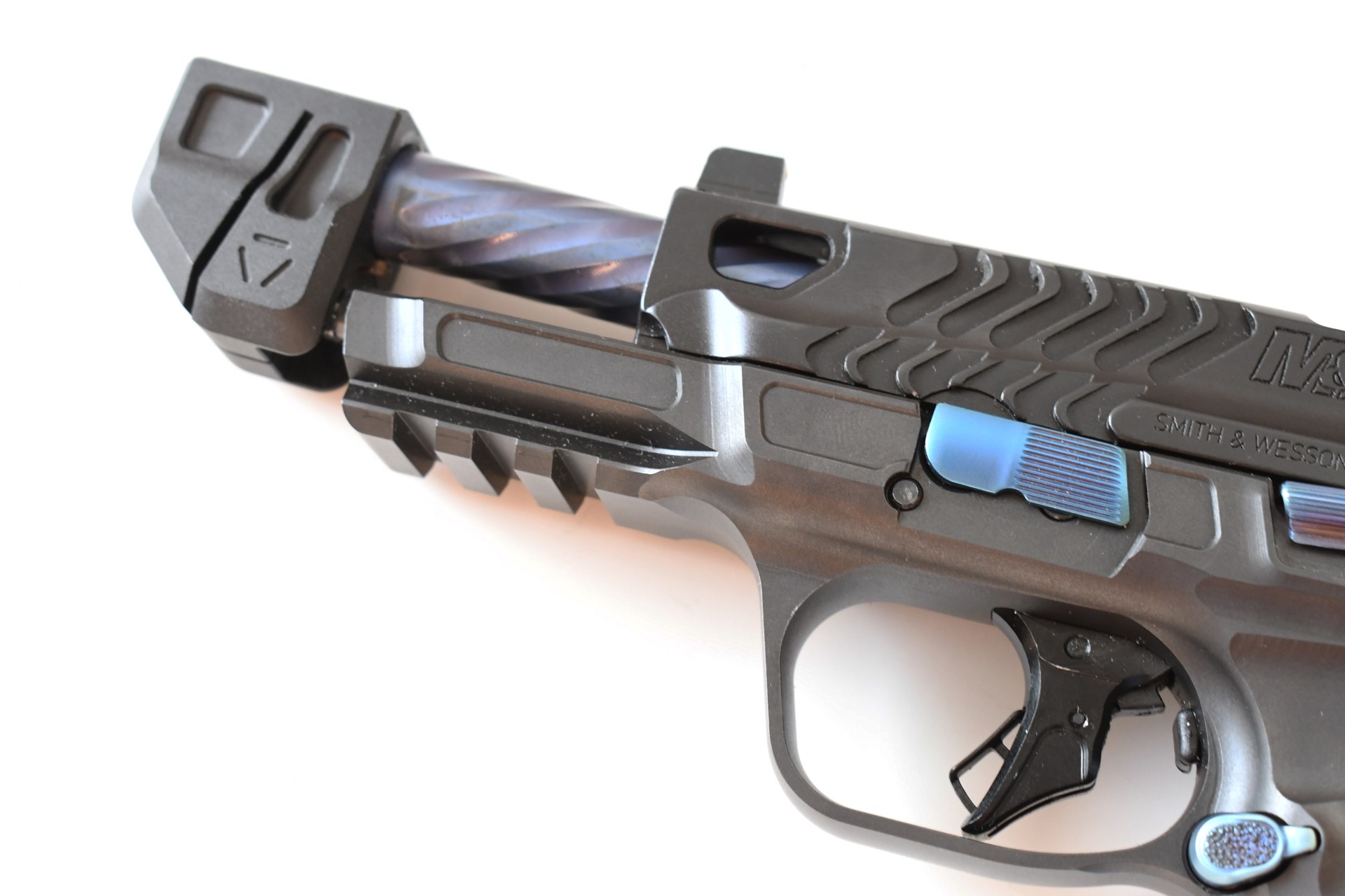 Spec Series V Smith & Wesson M&P 9 Metal HD pistol closeup with slide locked showing spiral-fluted barrel with compensator Picatinny rail trigger blue pvd accents on white background