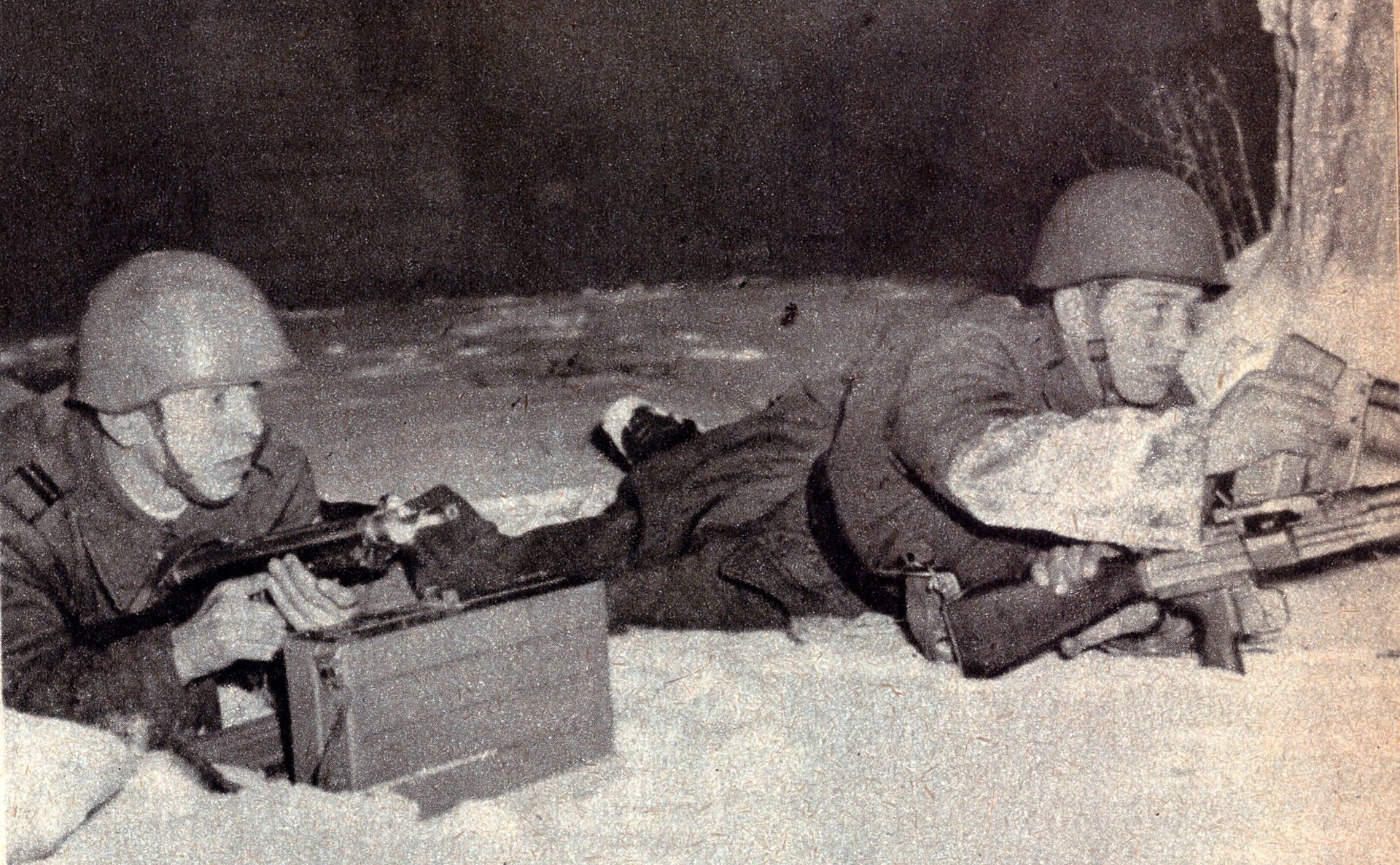 A Czech light machine gun team running a vz. 52 in 7.62×45 mm. The gunner (right) is inserting a magazine, and the assistant gunner (left) has positioned the magazine carrying box for the vz. 52 in the snow in front of him. He is armed with the Sa 23 (vz. 48a) submachine gun.