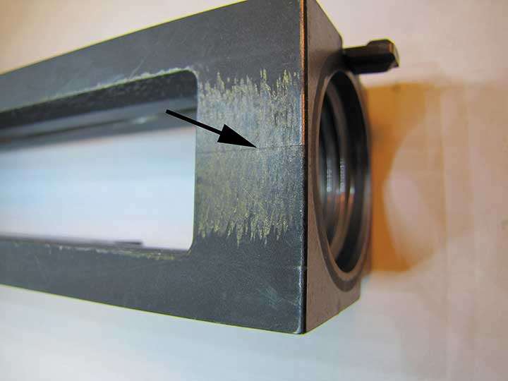 Underside of an M2HB machine gun receiver with an arrow pointing to a stress crack.