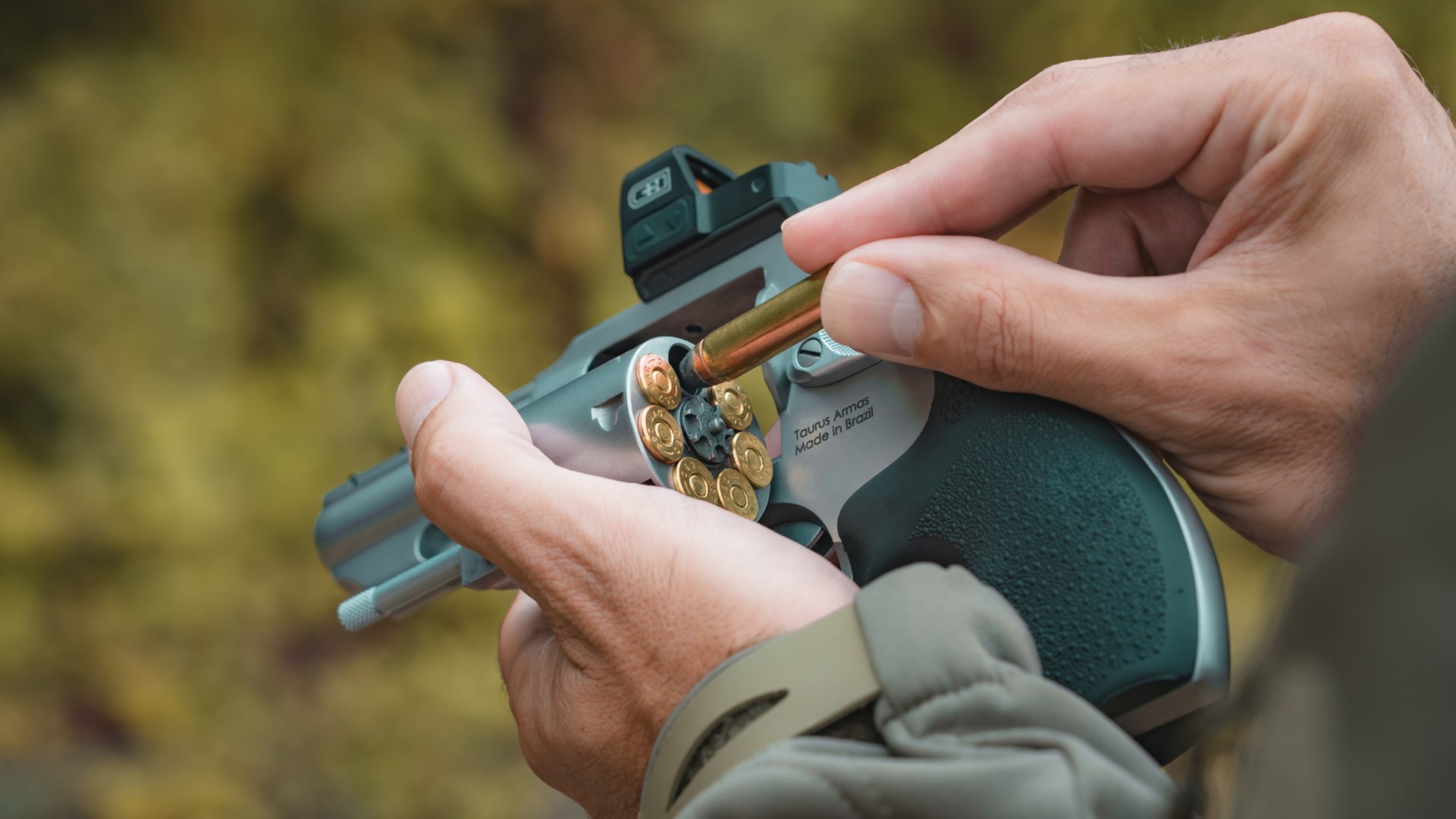 Man reloading a Taurus 66 Combat revolver equipped with a red-dot optic.