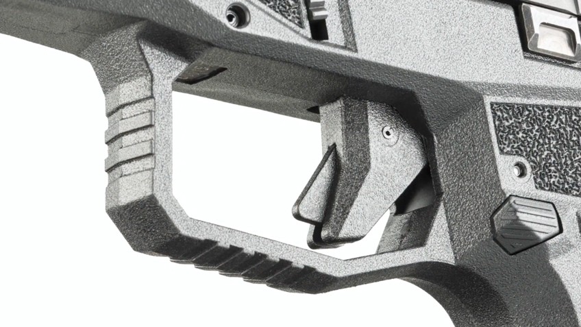 Close-up pistol trigger black plastic white background