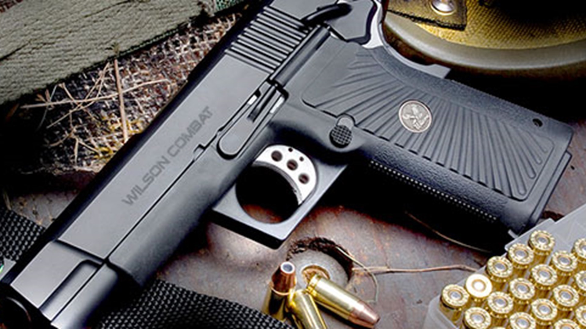 Wilson Combat Spec Ops 9 1911 pistol left-side angled view gun black finish shown with ammunition and accessories