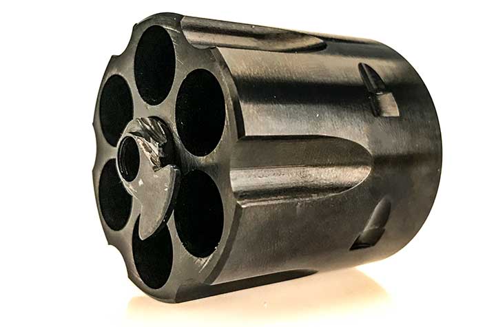 Cylinder from a Colt Single Action Army shown on white.
