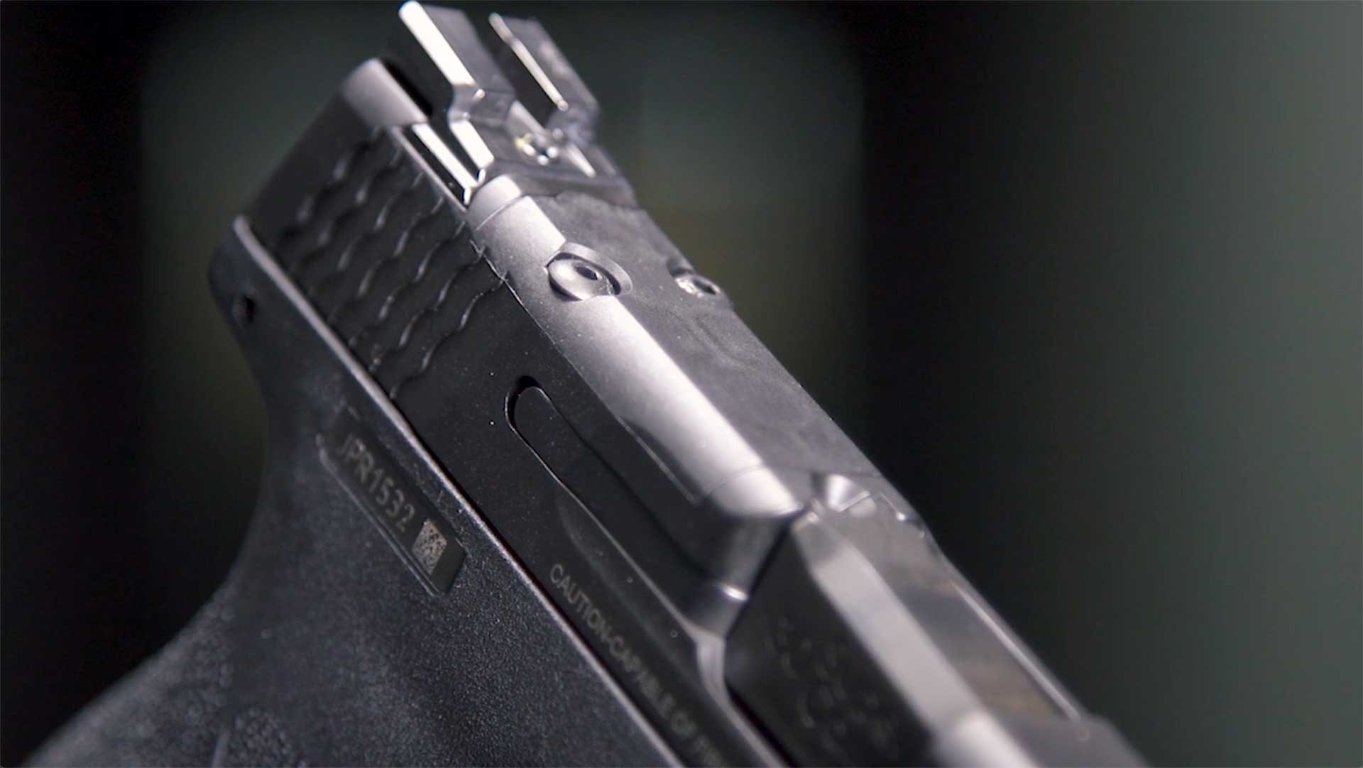 Milled slide shown on top of a Smith & Wesson M&P Shield Plus handgun.