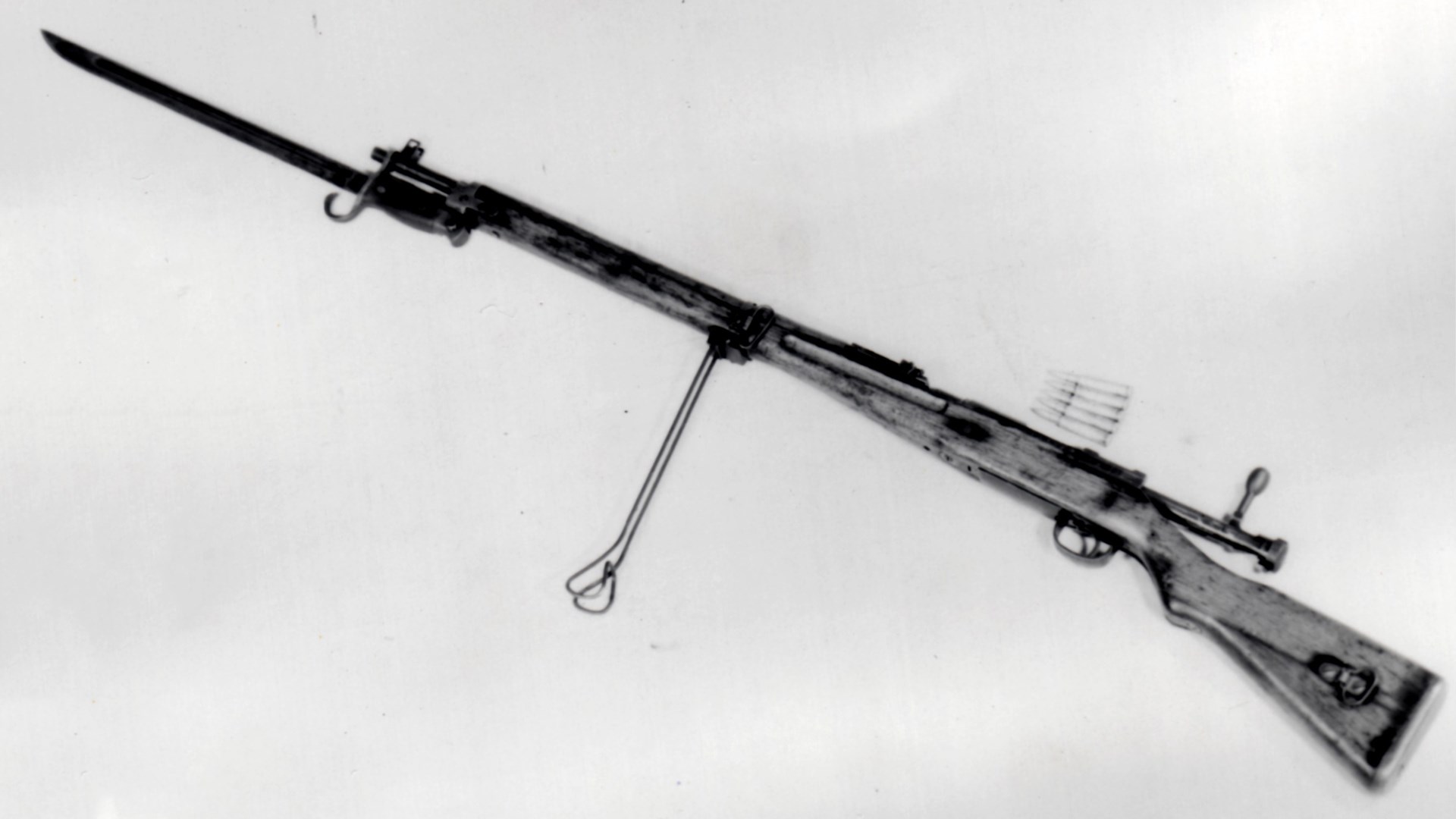 Japanese Type 99 Arisaka bolt-action rifle left-side view shown with bayonet ammunition clip wood stock wire bipod