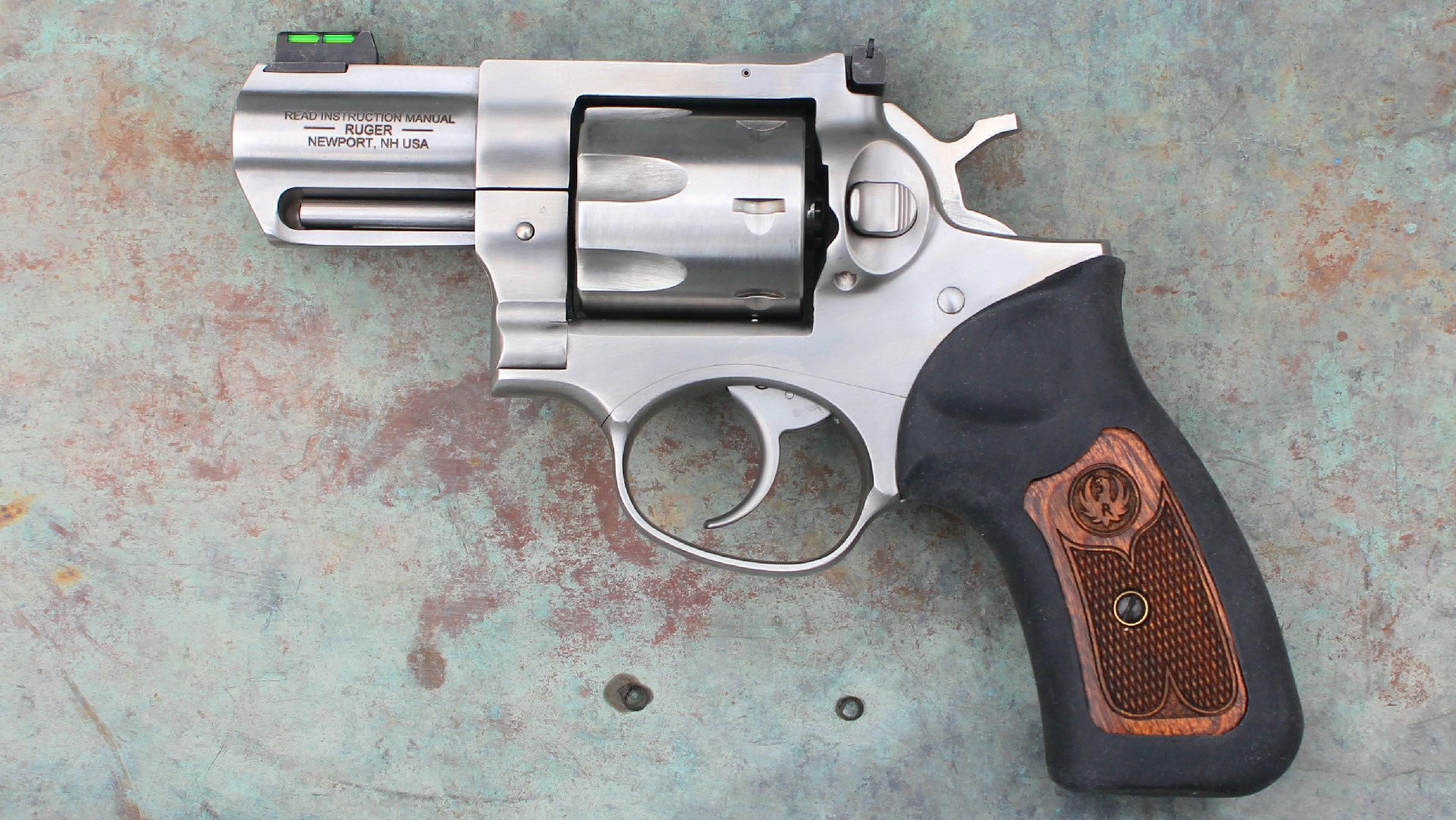 Ruger GP-100 revolver 7-shot gun stainless steel left-side view on concrete background rubber wood grips