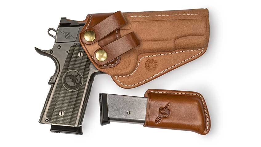 Nighthawk Custom 1911 pistol and magazine in brown holster on white background.
