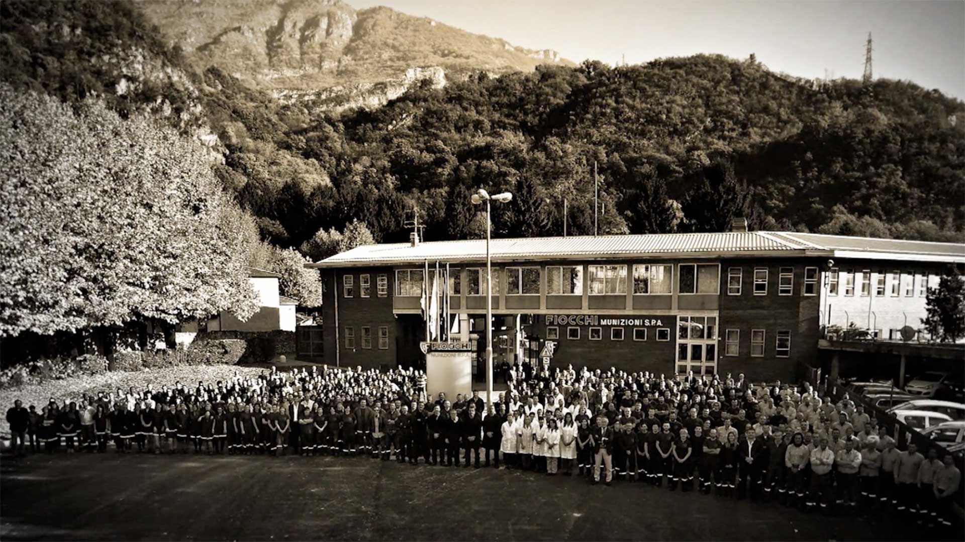 An archival photo of the Fiocchi munitions plant in Italy, with the company staff standing outside the manufacturing building.