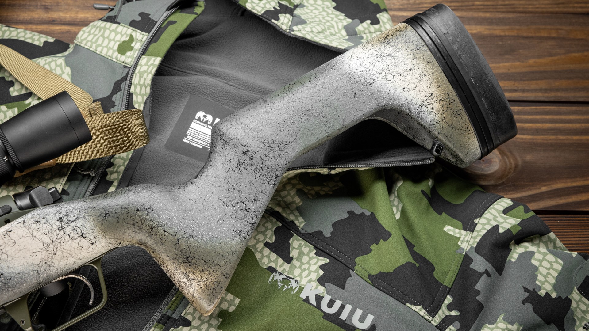 The hollowed-out minimalist buttstock from Grayboe Stocks shown on the Springfield Model 2020 Redline on top of a Kuiu camouflage coat.