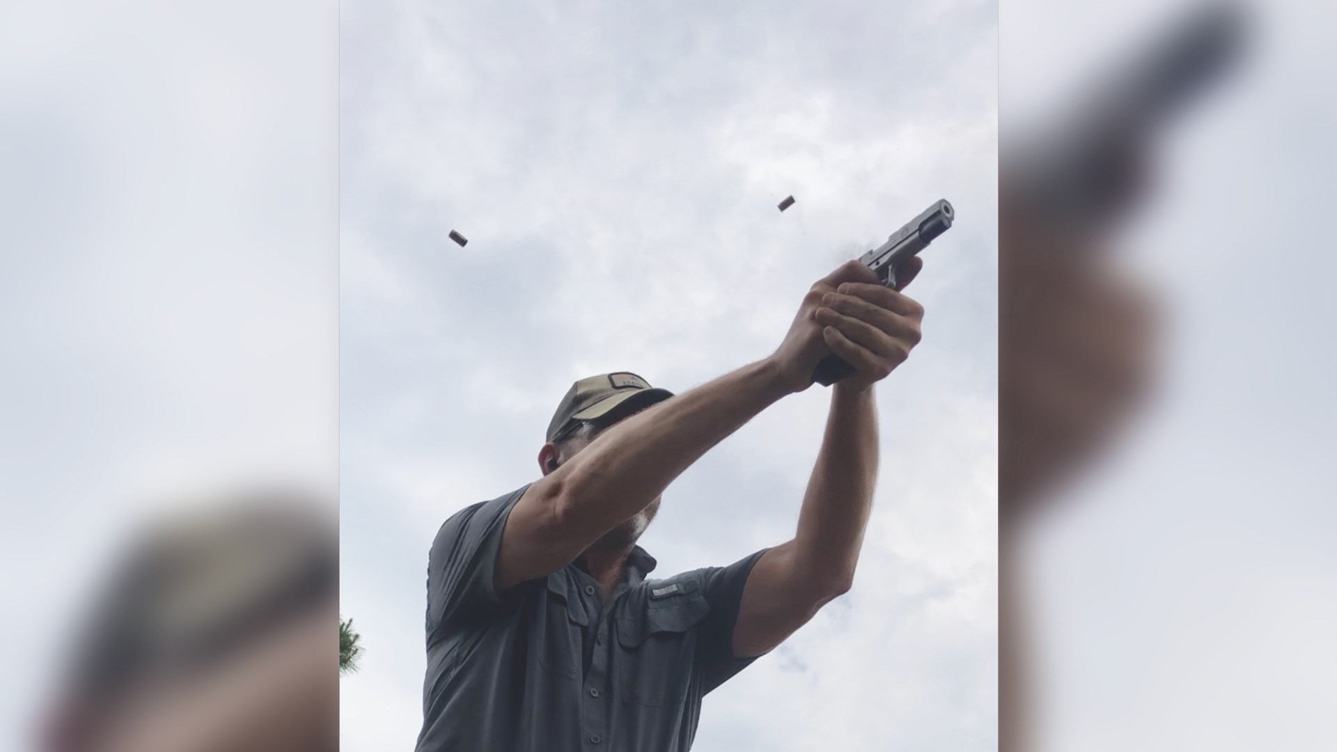 overlay image blur background copy of foreground skylight clouds spent brass in air coming out of 1911 man shooting ballcap with his face covered by arm camera point up from ground