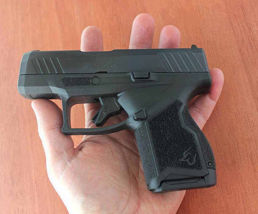 Taurus GX4 semi-automatic black handgun pistol in hand size comparison