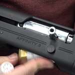 Close-up, right-side view Franchi Affinity 3 Sport Trap shotgun being loaded with white brass shotshell in hands