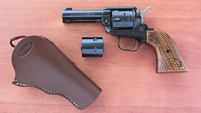 black revolver and spare cylinder leather holster wood table