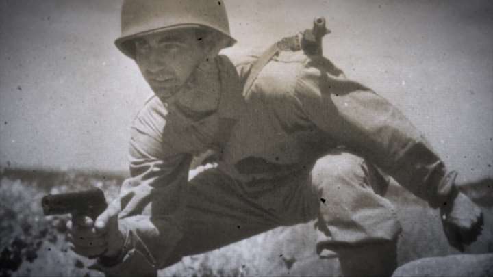World War II American soldier holding his Remington Rand M1911A1 pistol.