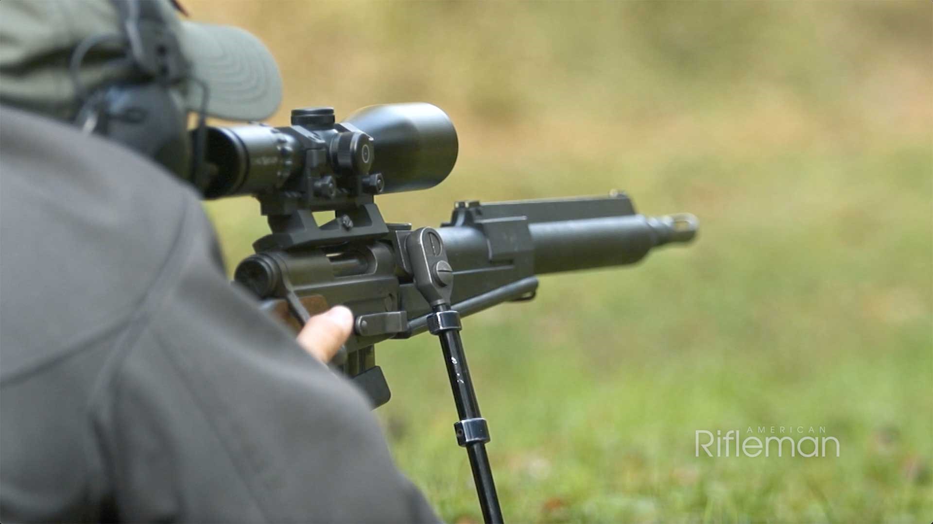 Man aiming FRF2 sniper rifle on a green, grassy range.