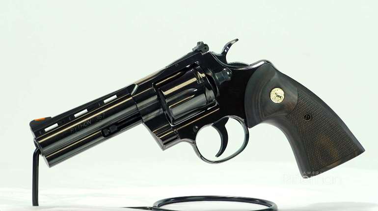 Colt Blued Python left-side view on wire stand shown with walnut target grips and gold medallion