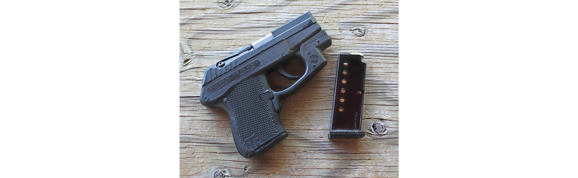 Keltec p32 pistol small handgun black with magazine on wood table