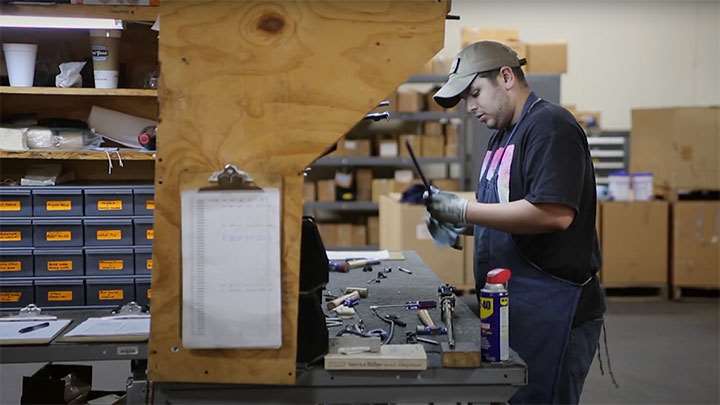 A CMP armorer inspecting the components of a surplus M1 Garand rifle.