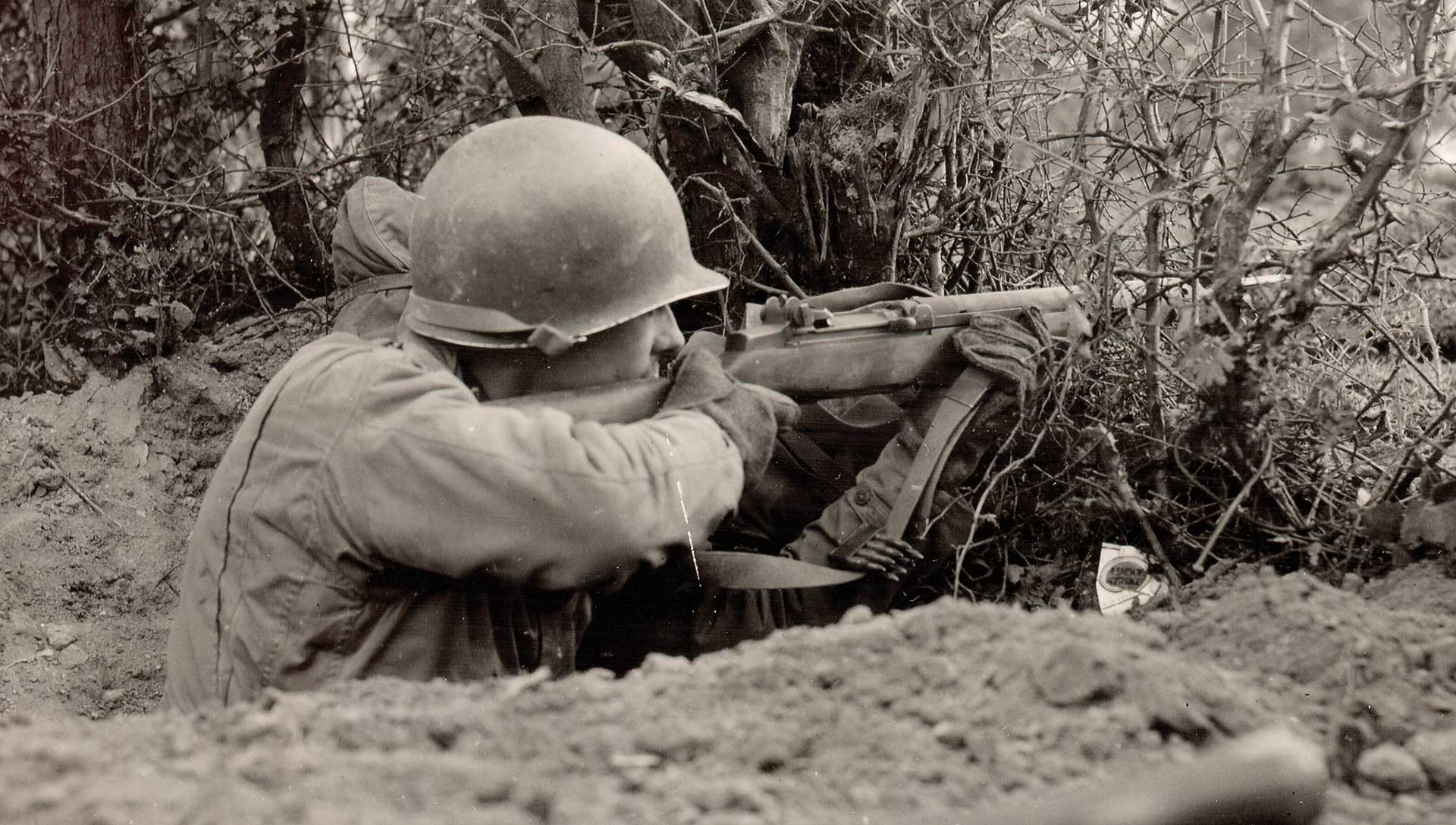 soldier foxhole helmut rifle outdoors dirt bushes