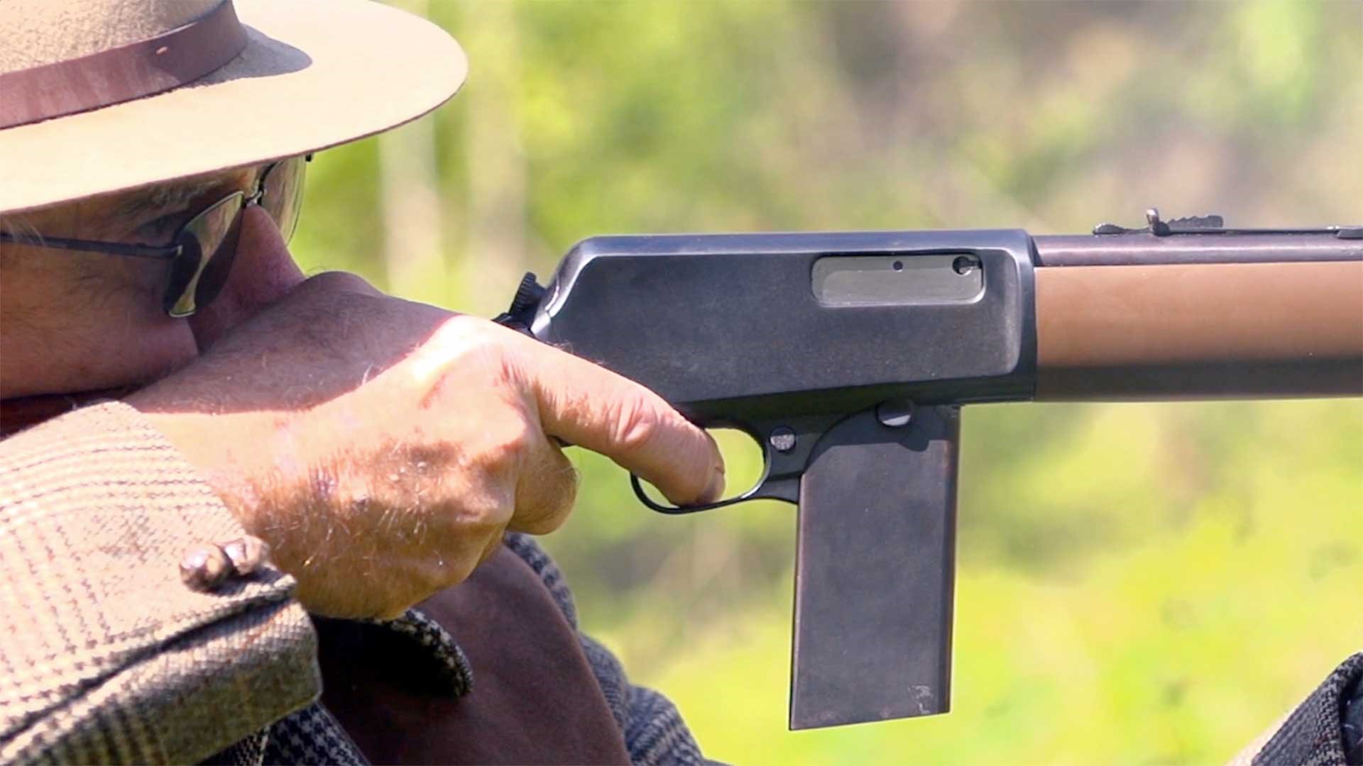 Right-hand view of the Winchester Model 1907 rifle being fired on an outdoor range.