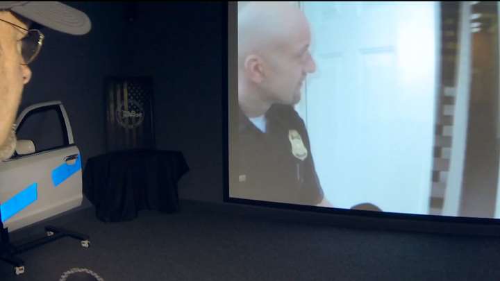 Training simulation screen with police officer.