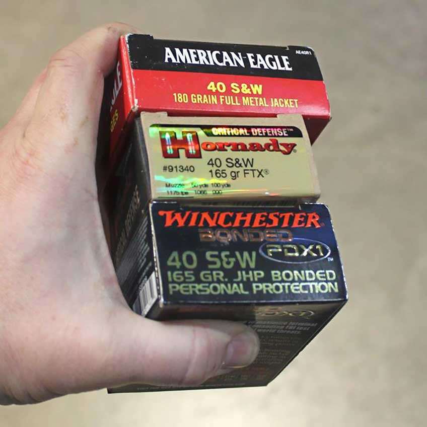 Federal Hornady and Winchester .40 smith &amp; Wesson ammunition boxes in hand outdoors