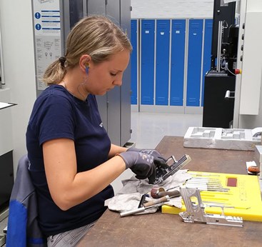 woman at table with gun parts fininshing assembly manufacturing handgun pistol