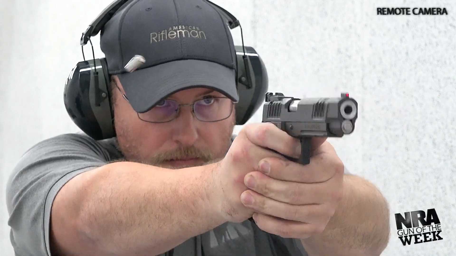 Man wearing ballcap ear protection glasses shooting Staccato XL handgun