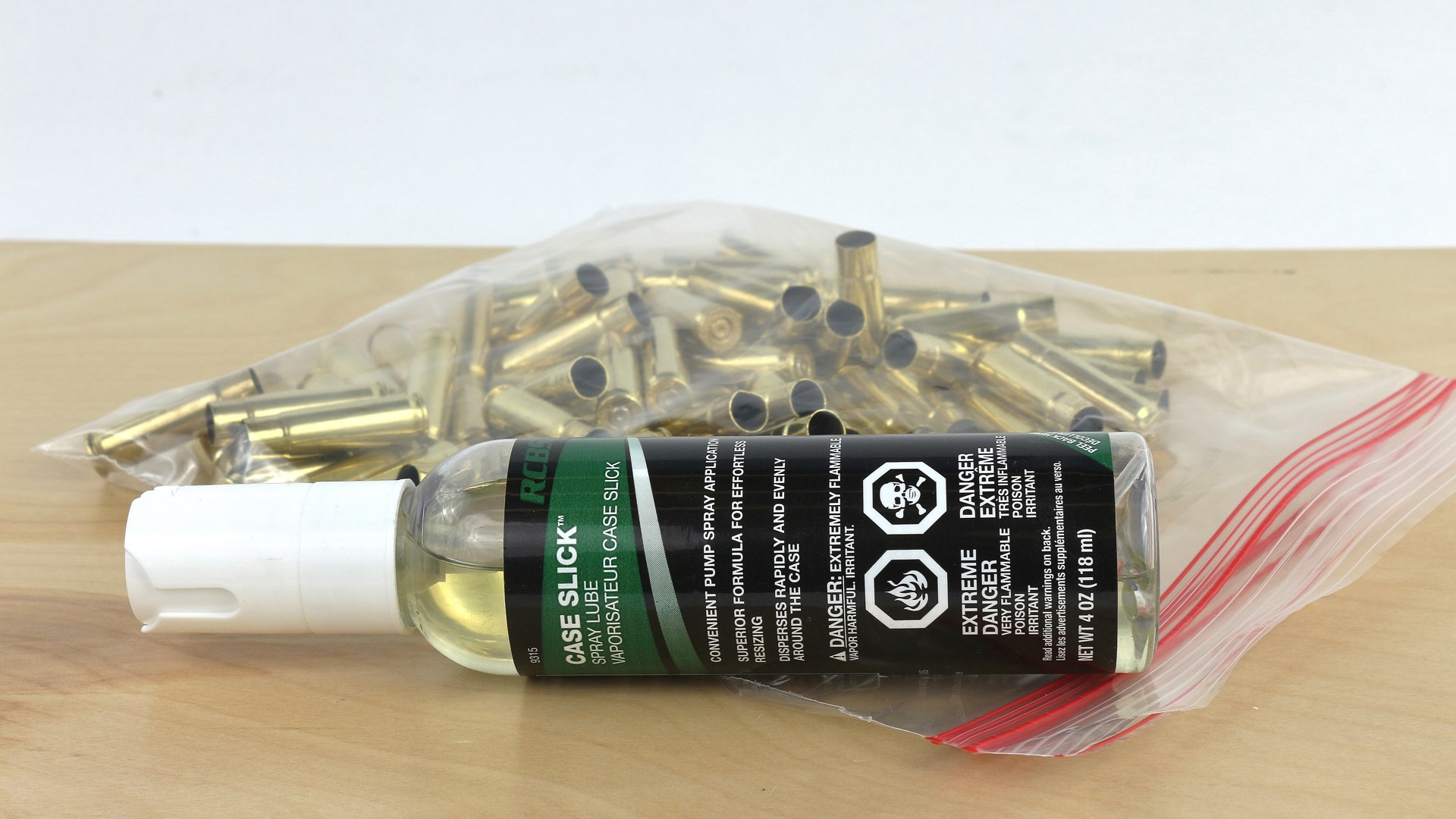 Case Slick RCBS spray lubricant bottle on left side near ziplock bag of ammunition brass cases